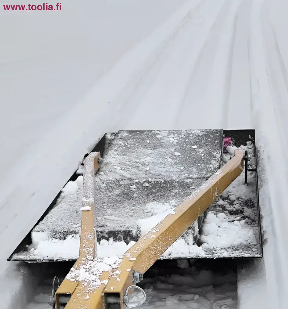 Keltainen metallinen latuhöylä FIS-mitoilla, musta runko lumessa