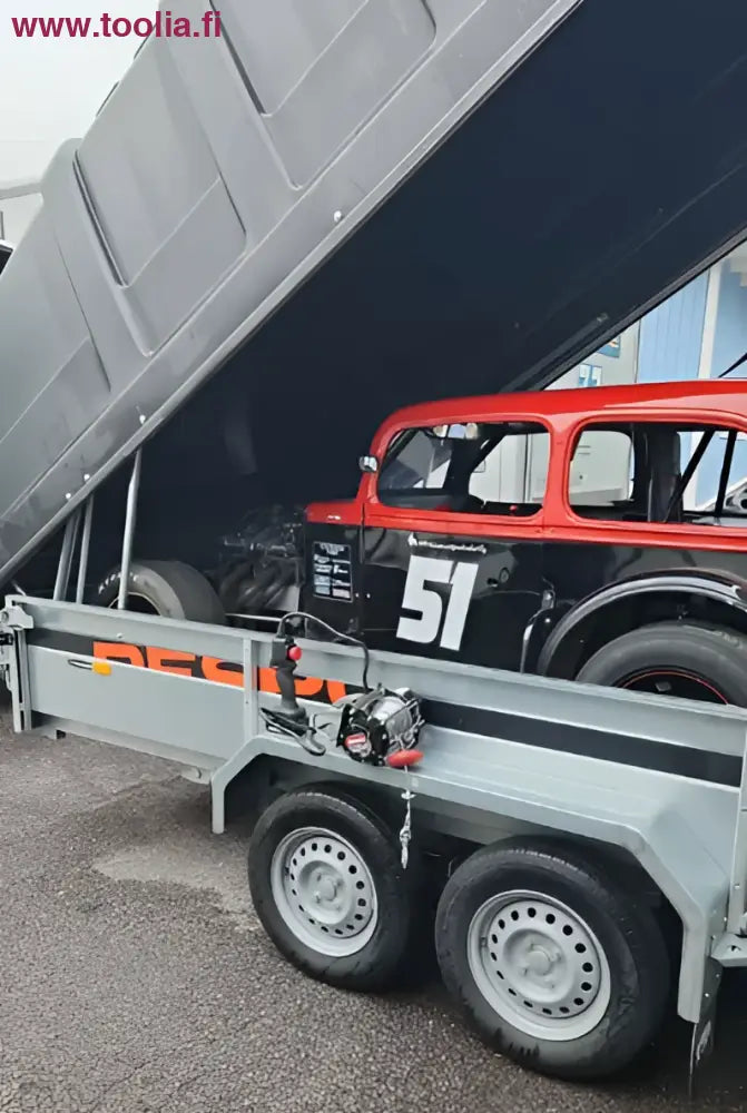 Punainen ja musta vintage kilpa-auto numero 51 Robota 18V akkuvinssillä trailerilla