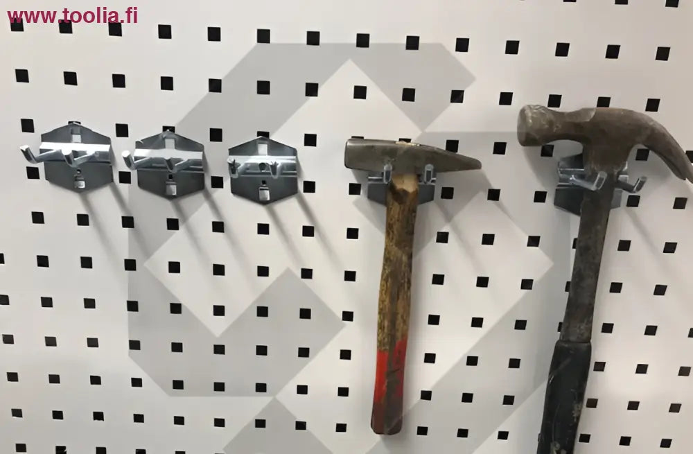 Kaksi ruostunutta vintage vasaraa puurakkoisilla kahvoilla robota reikälevyseinätarvikkeessa